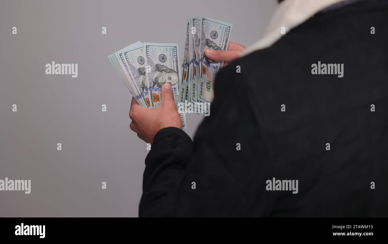 American dollars or US dollars: hands counting one hundred American money or 100 USD. Stock Photo