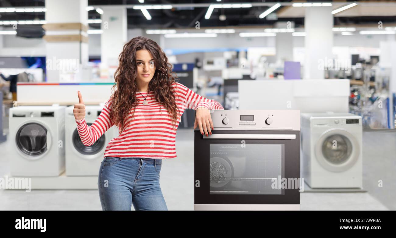 Young woman leaning on an oven at a shop Stock Photo