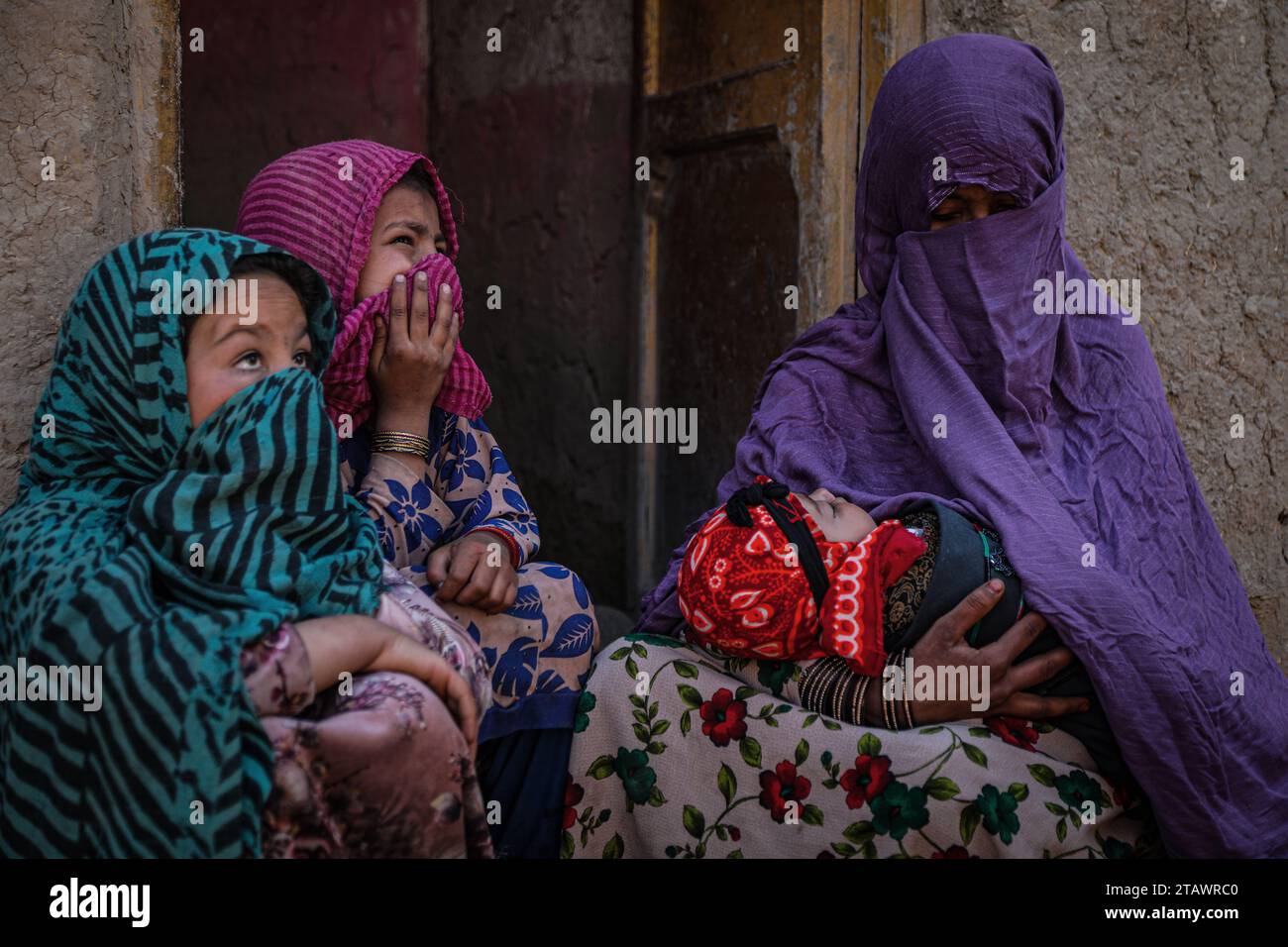 A sad widow in need, accompanied by her children, represents Afghan families facing poverty and hardship | Refugee family. Stock Photo