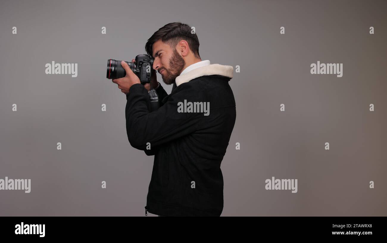 A photographer capturing photos with a camera against a gray background ...