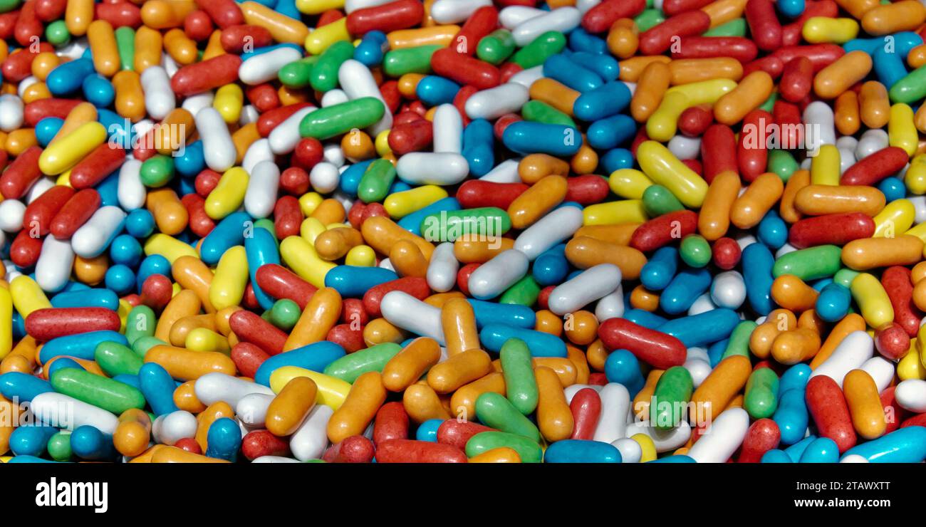 The image shows a pile of oblong candy in various colors. Stock Photo