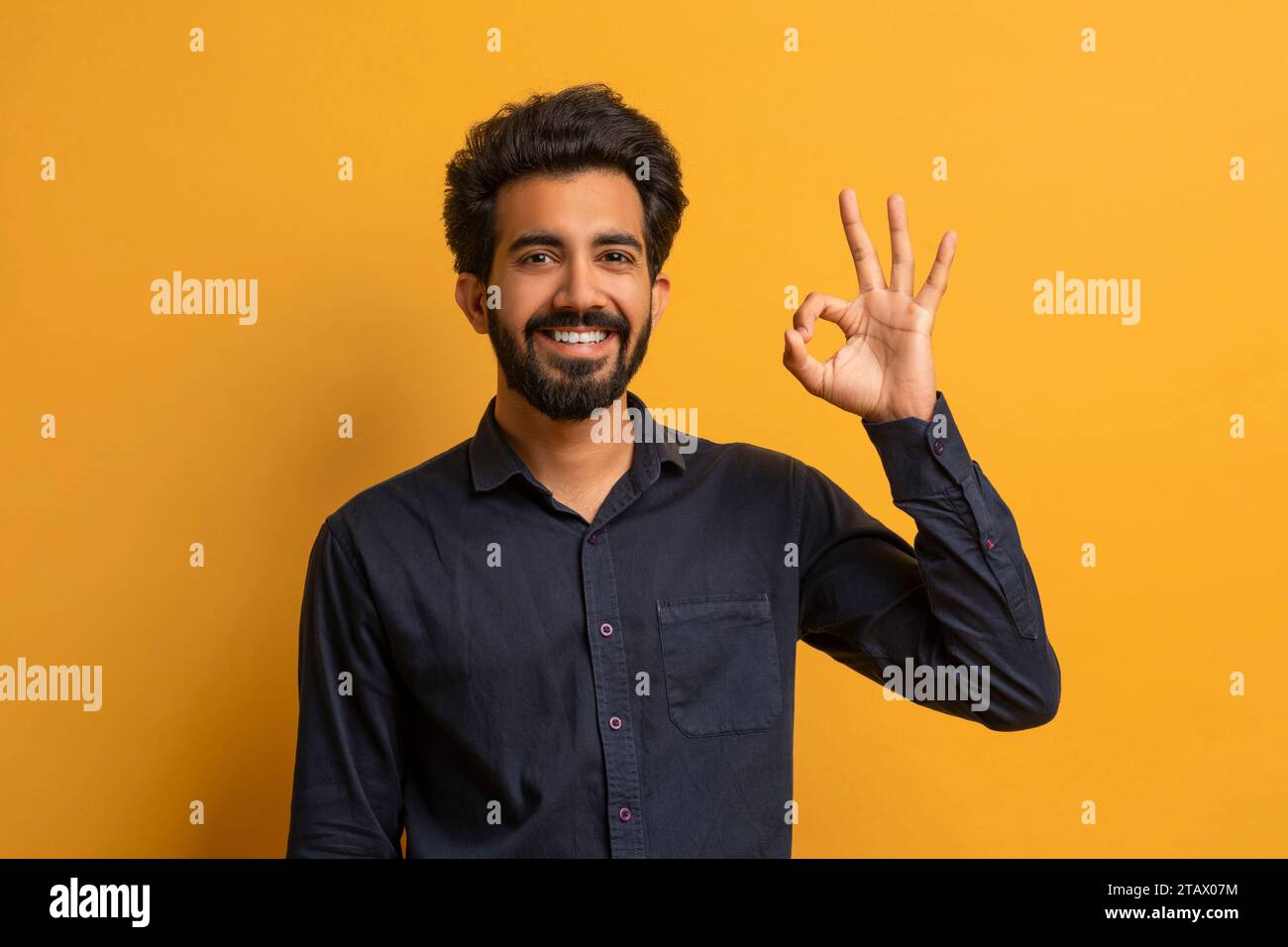 Young smiling indian man making 'OK' gesture at camera Stock Photo