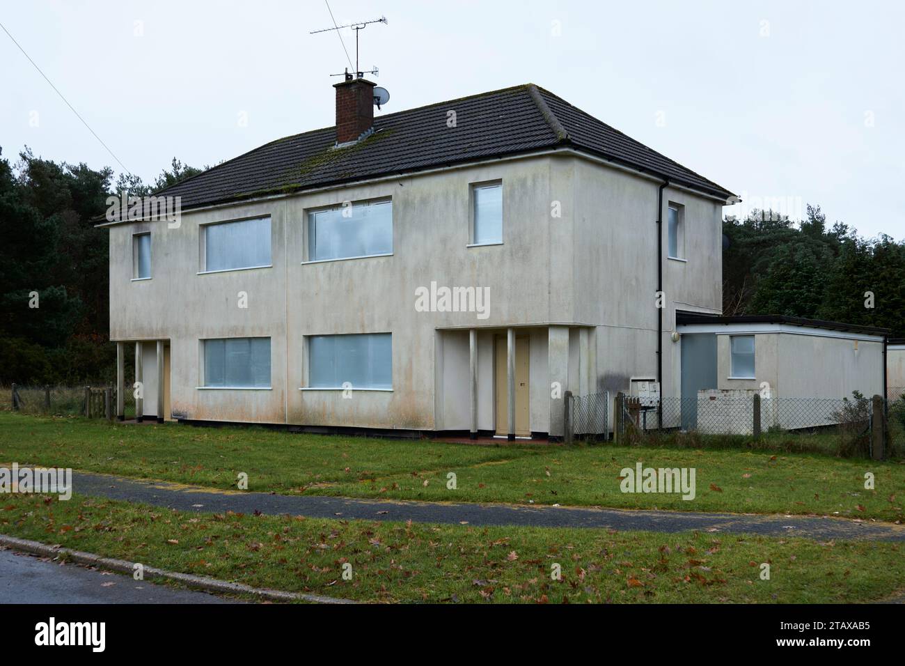 Disused condemned houses boarded up with steel shutters Stock Photo