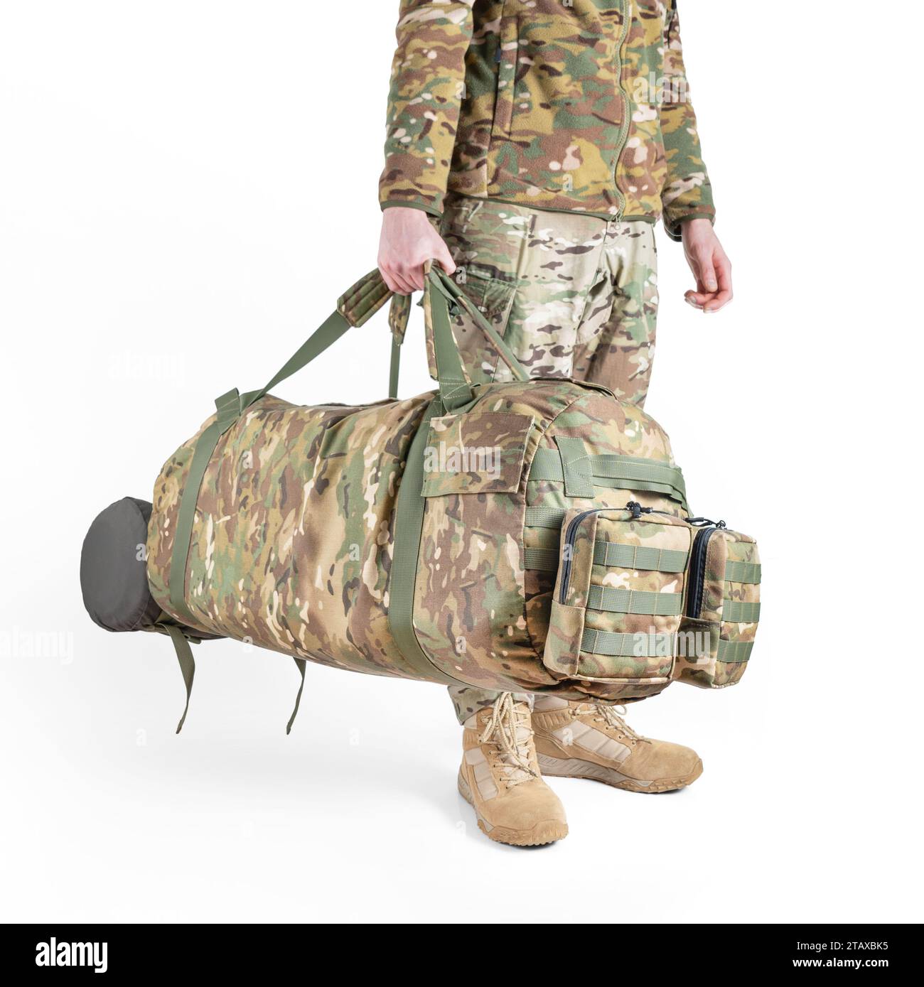Soldier in a military uniform holds camouflage bag in his hands on white background. Armed forces concept. Stock Photo