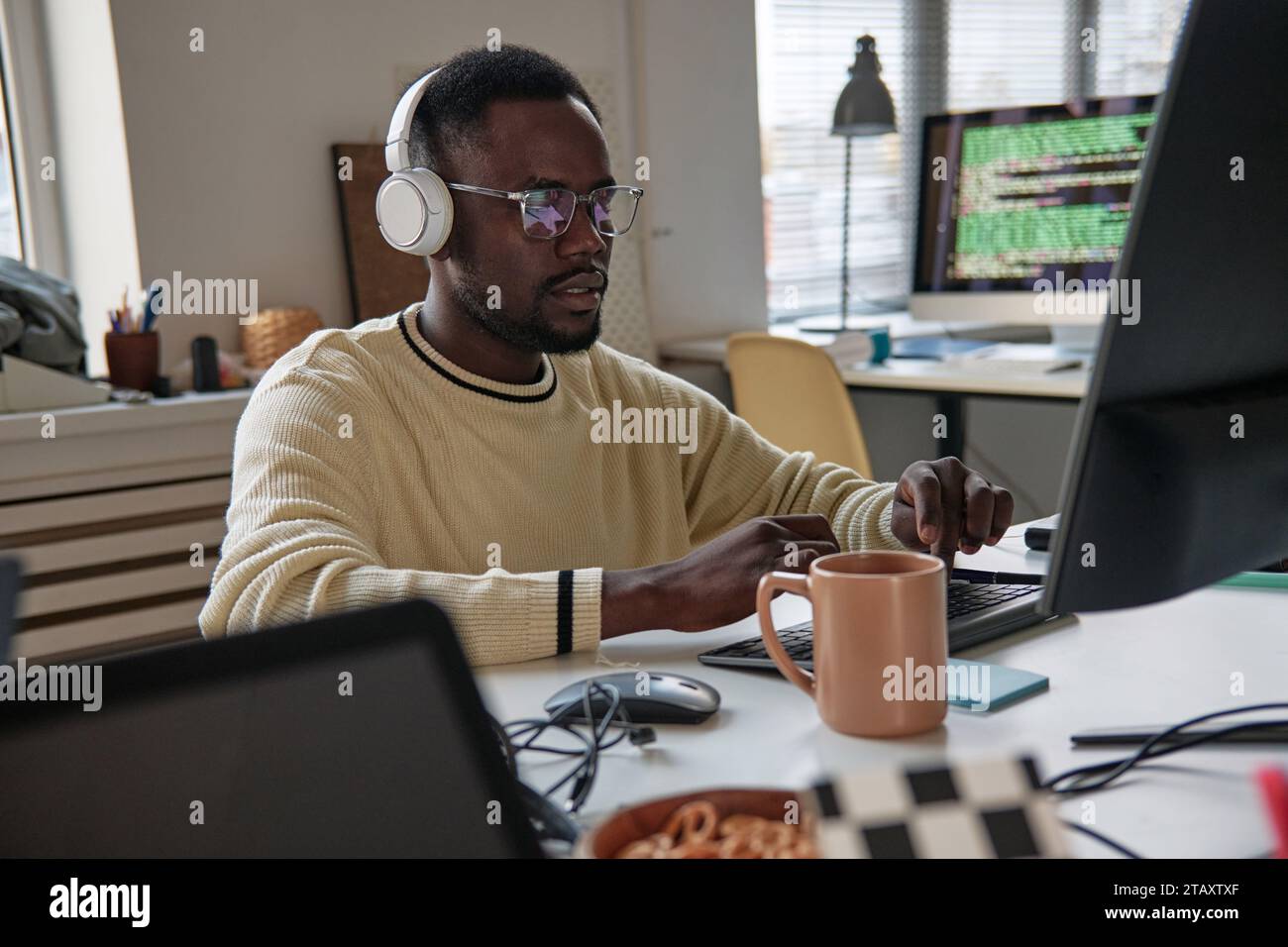 Young man programming on laptop working on new application Stock Photo