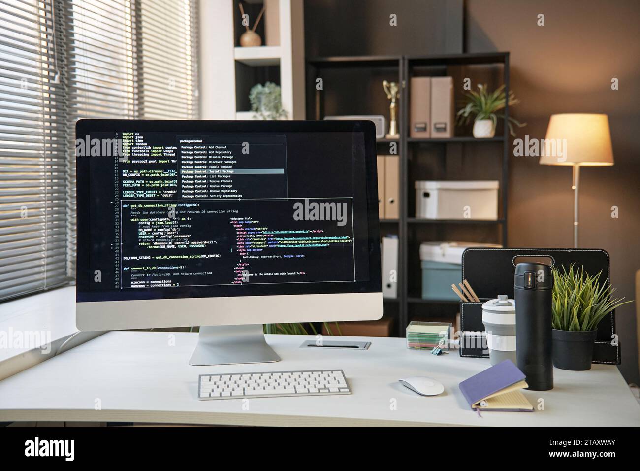 Computer monitor with programming code on screen on office desk Stock Photo