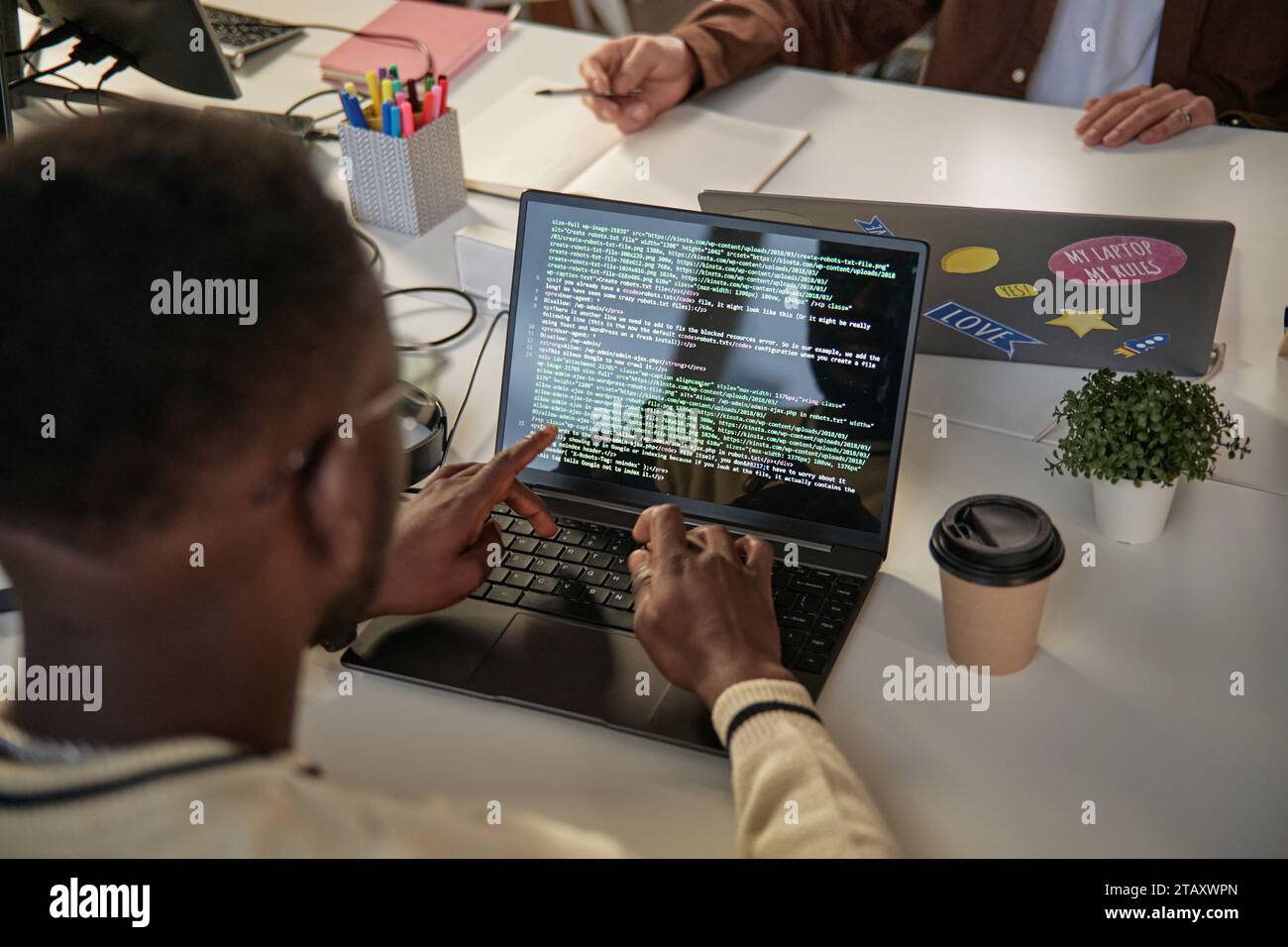 Software developer producing efficient and elegant code, view over the shoulder Stock Photo