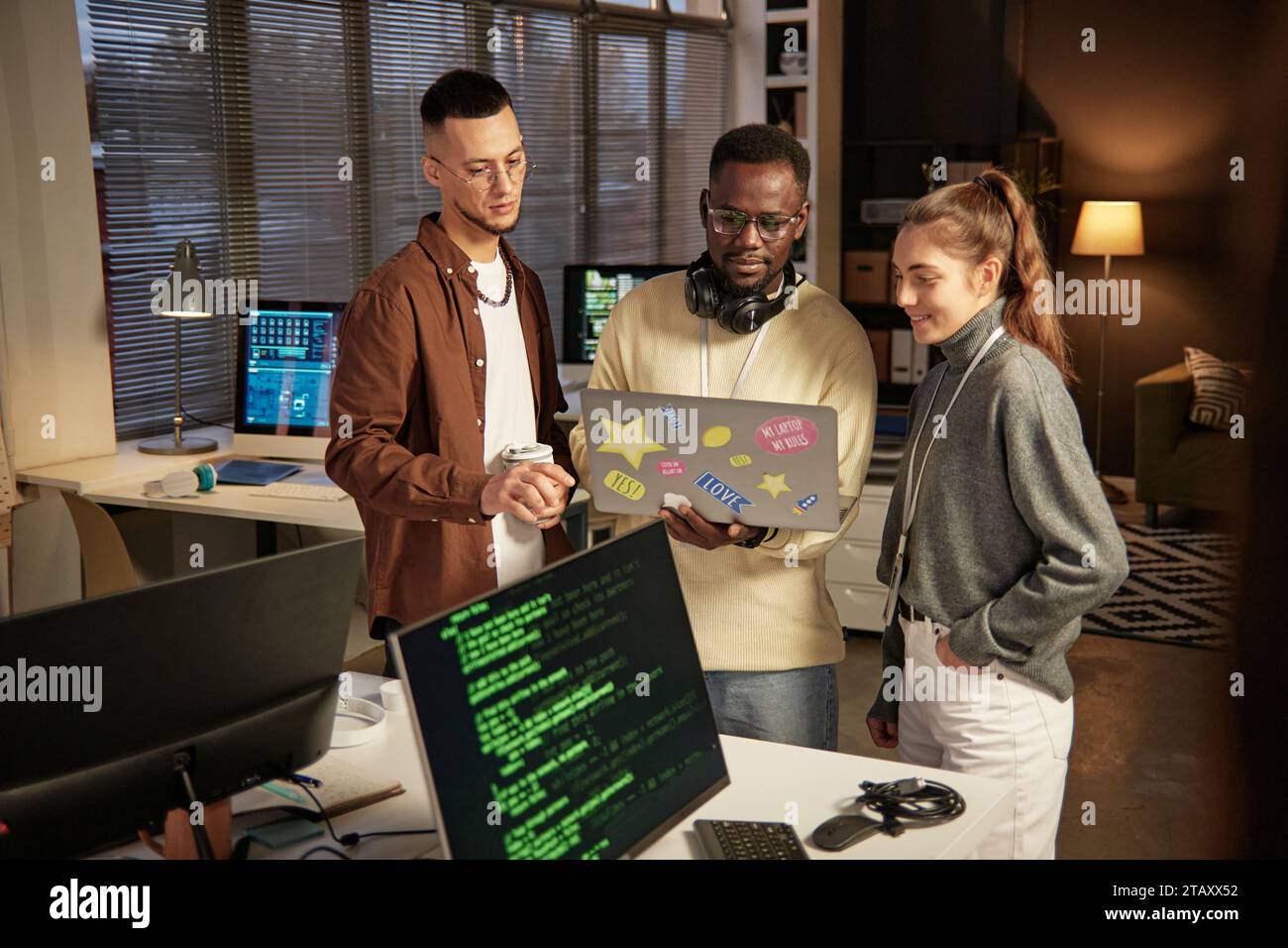 Group of software developers launching program on laptop to check how it works Stock Photo