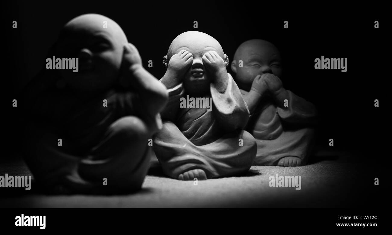 I hear nothing, I see nothing, I say nothing. Small gray Asian monk figurines. Stock Photo