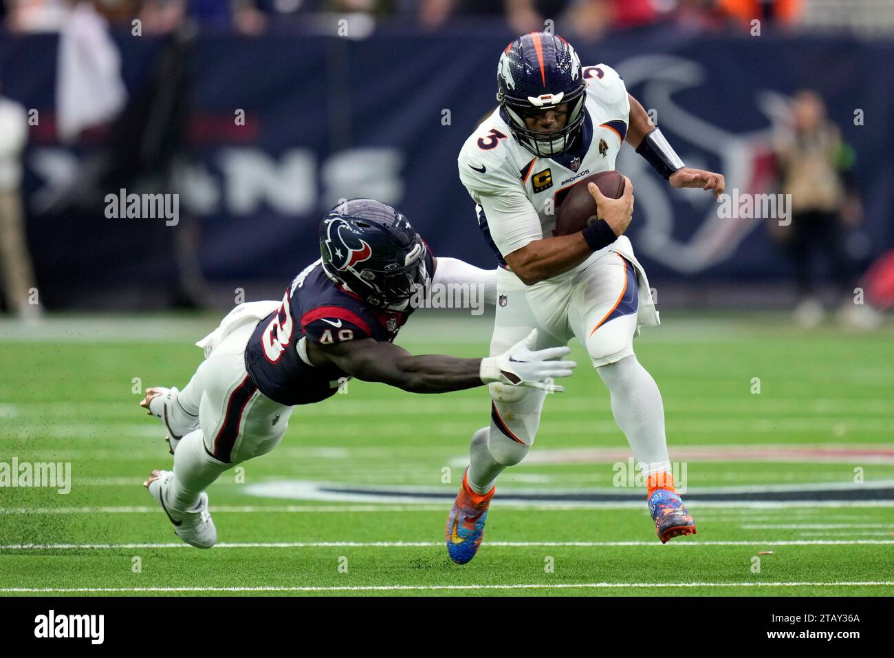 Denver Broncos quarterback Russell Wilson (3) scrambles past Houston ...