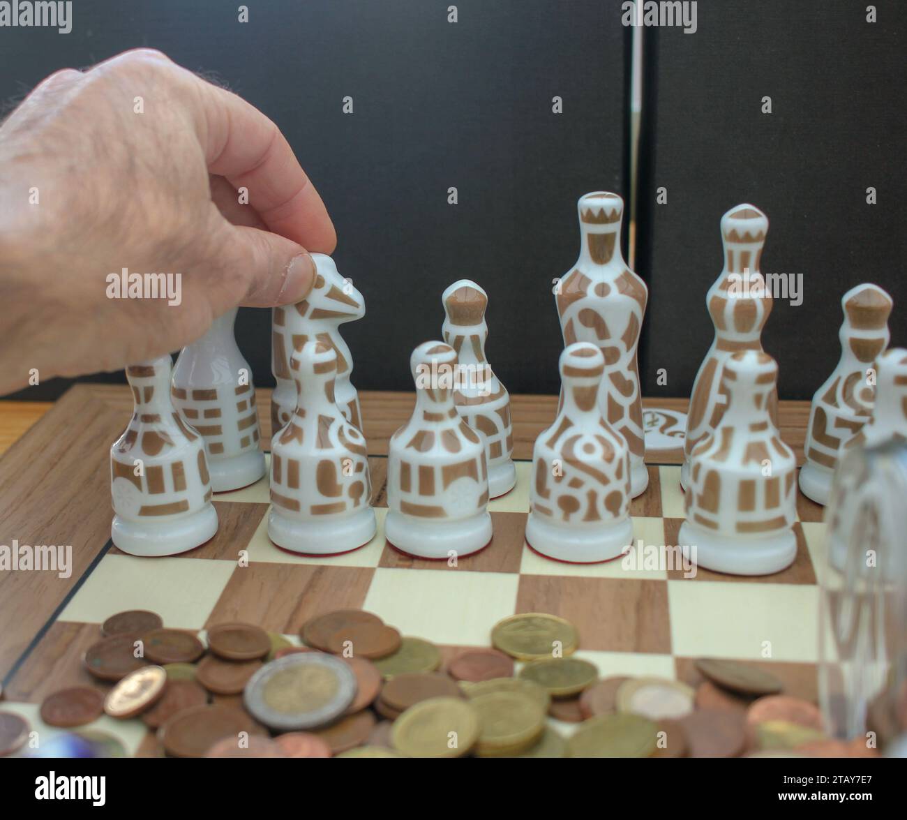 moving the pieces of chess with my hand. Concept, deciding about where to invest Stock Photo