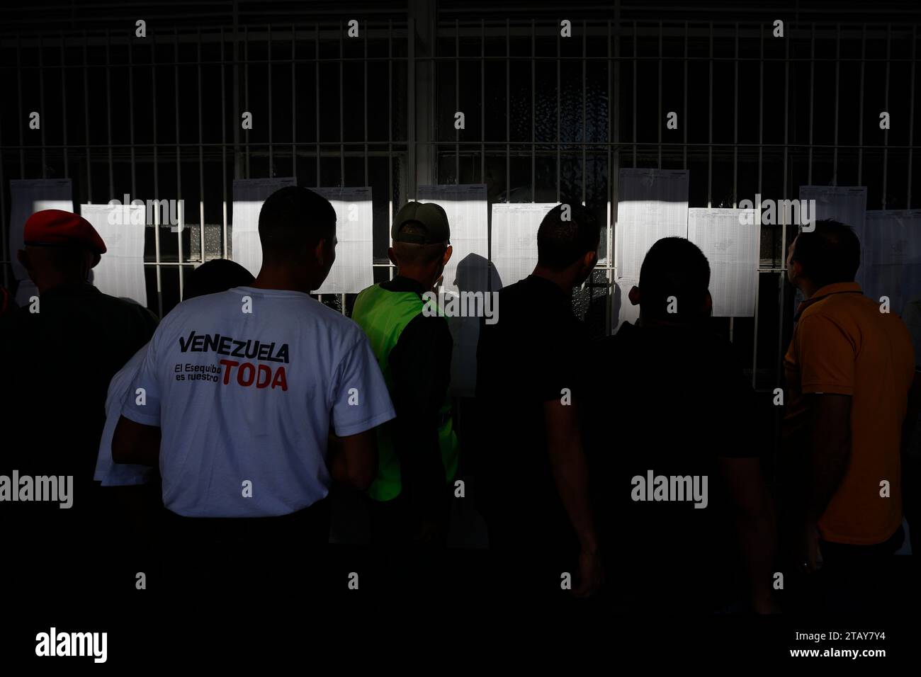 Caracas, Venezuela. 03rd Dec, 2023. A group of people search for their ID number in the lists at their polling station during the referendum on the future of the disputed territory of Essequibo with Guyana. On Sunday, the citizens of Venezuela will vote in a referendum on whether their country should annex two thirds of the neighboring state of Guyana. At stake is the resource-rich region of Esequibo, which Venezuela has claimed as its territory for more than 100 years. Credit: Jesus Vargas/dpa/Alamy Live News Stock Photo