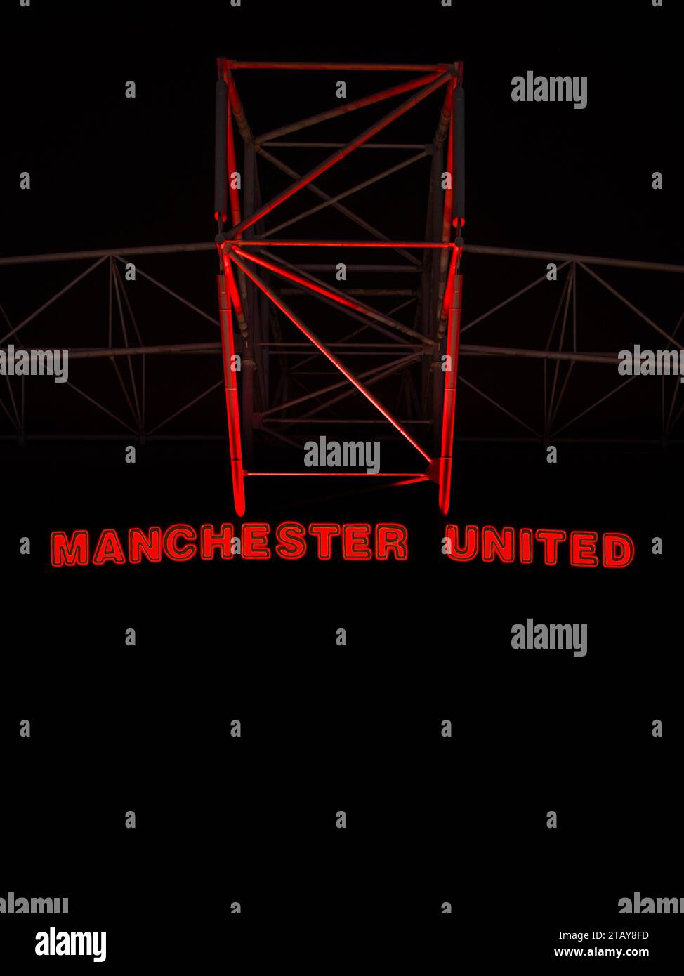 Outside at Old Trafford at night.  Manchester United stadium with just the red logo highlighted. Stock Photo