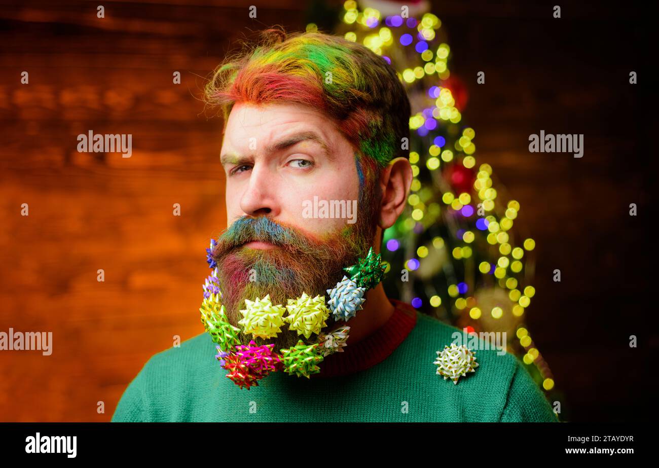 Merry Christmas and Happy New year. Serious bearded man with decorated beard for Christmas or New year party. Christmas beard decorations. Closeup Stock Photo