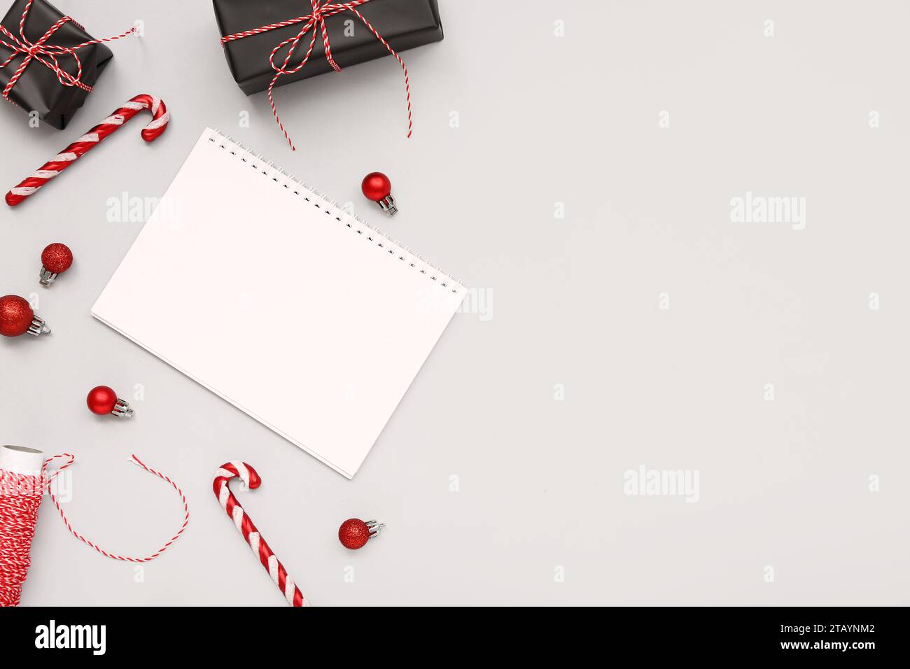 Blank paper calendar with gift boxes and Christmas decorations on grey ...