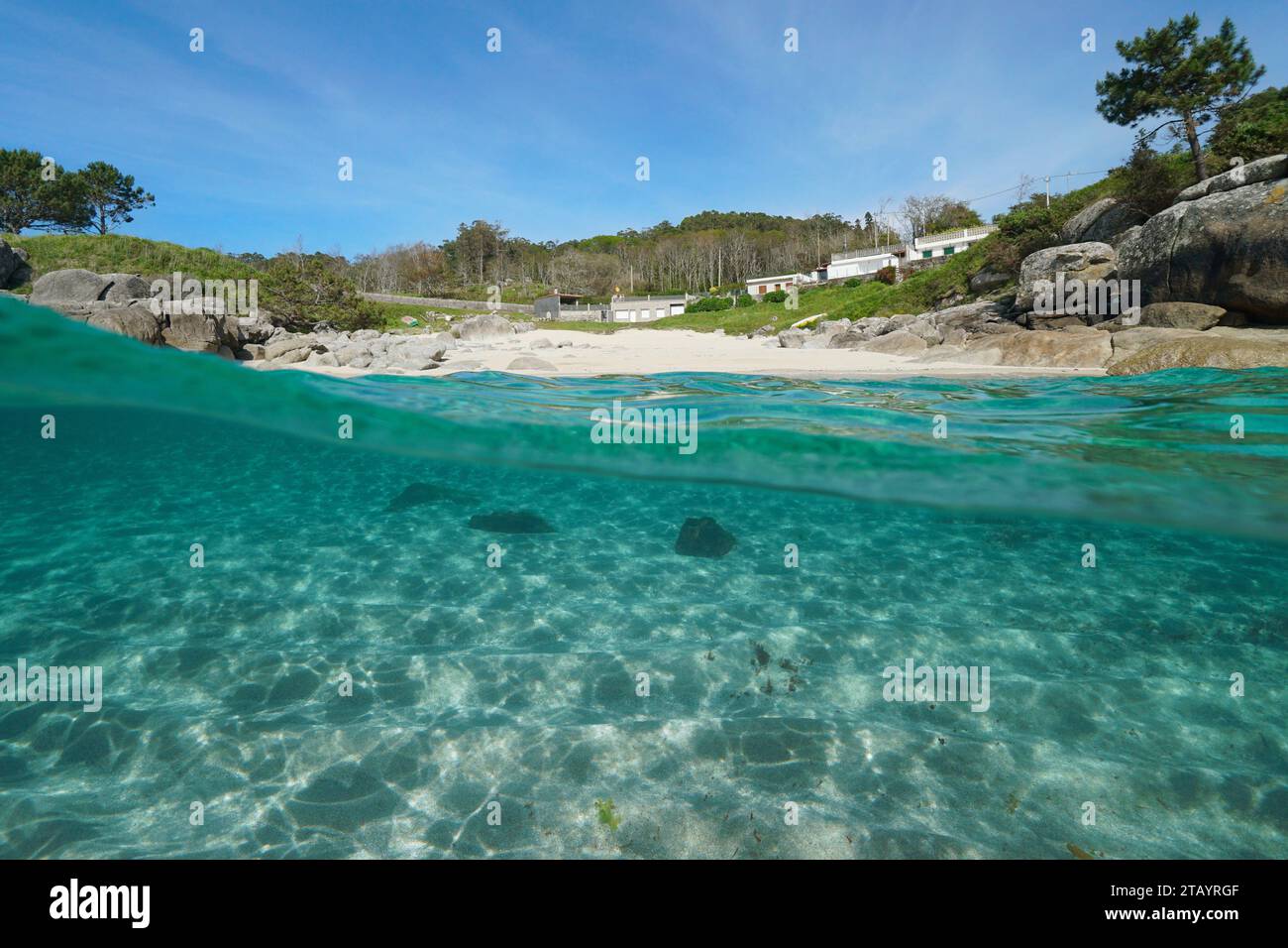 Beach with sand and rocks on the Atlantic coast in Spain, split view over and under water surface, natural scene, Galicia, Rias Baixas, Bueu Stock Photo