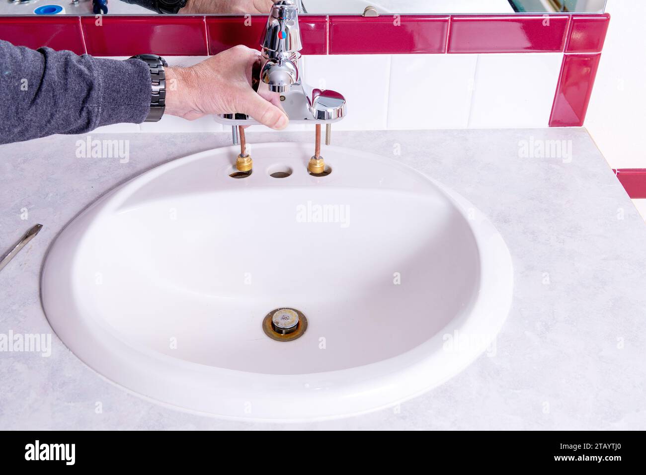Chrome bathroom faucet installation Stock Photo - Alamy