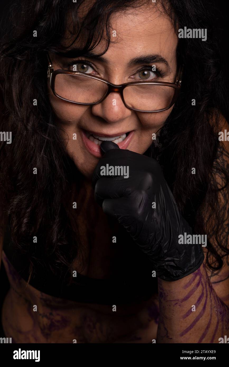 Woman artist posing with painted and tattooed body against black background Stock Photo