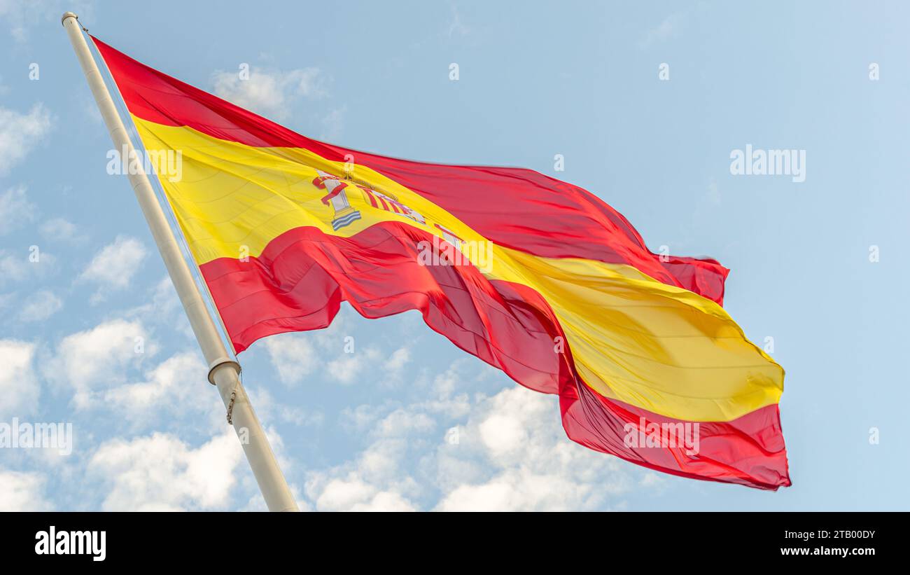 Spanish flag waving in the wind on cloudy blue sky background Stock ...