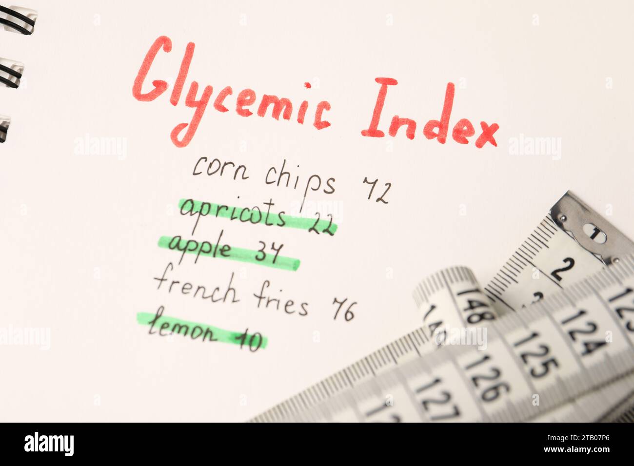 Glycemic Index. Notebook with information and measuring tape, closeup Stock Photo