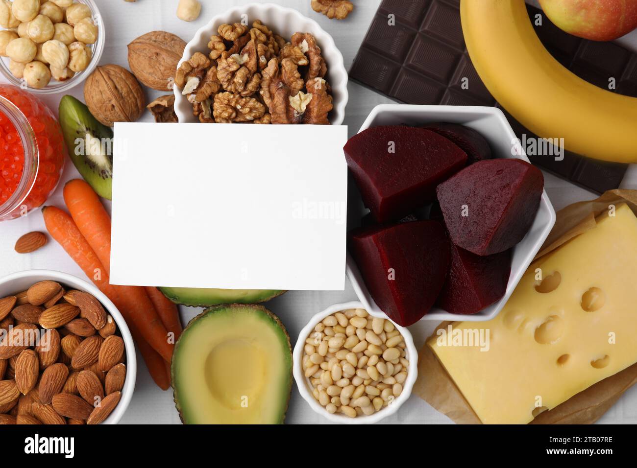 Many different products and blank card on white table, flat lay. Natural sources of serotonin Stock Photo