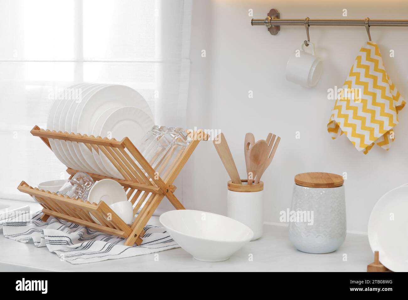 Kitchen sink with dishes on dry rack and hanging pans Stock Photo - Alamy