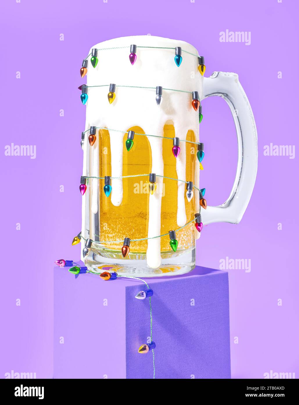 A Mug of Ale Beer Wrapped with Christmas String Lights on a Pastel Purple Background Stock Photo