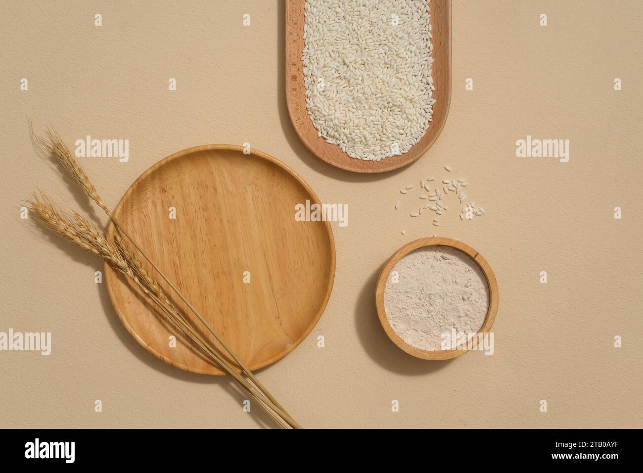 Wooden plates with different shapes and whole rice are displayed on the