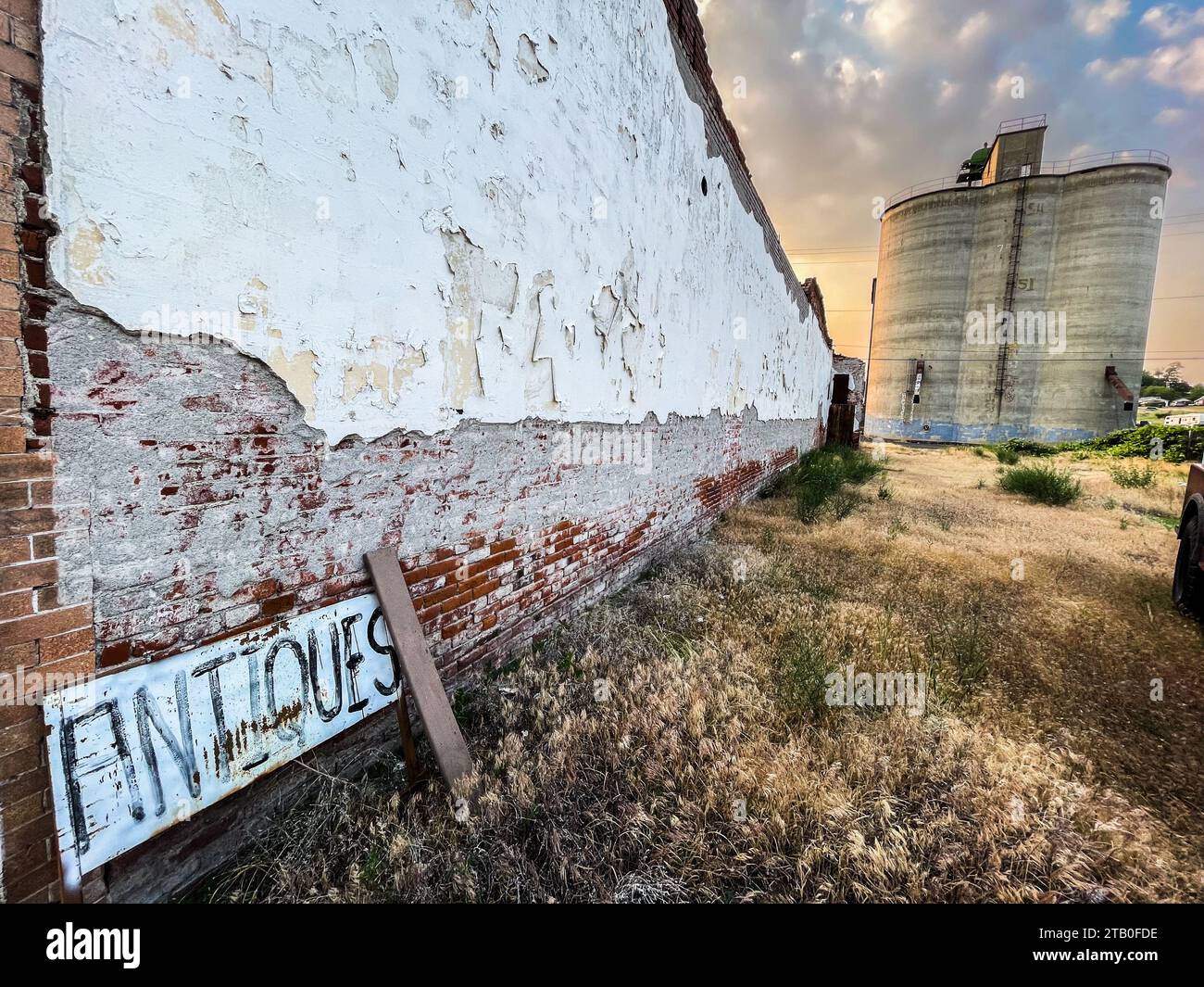 Dry scene of crumbling wall and grain elevator in the eastern Washington USA town of Sprague, WA. Stock Photo