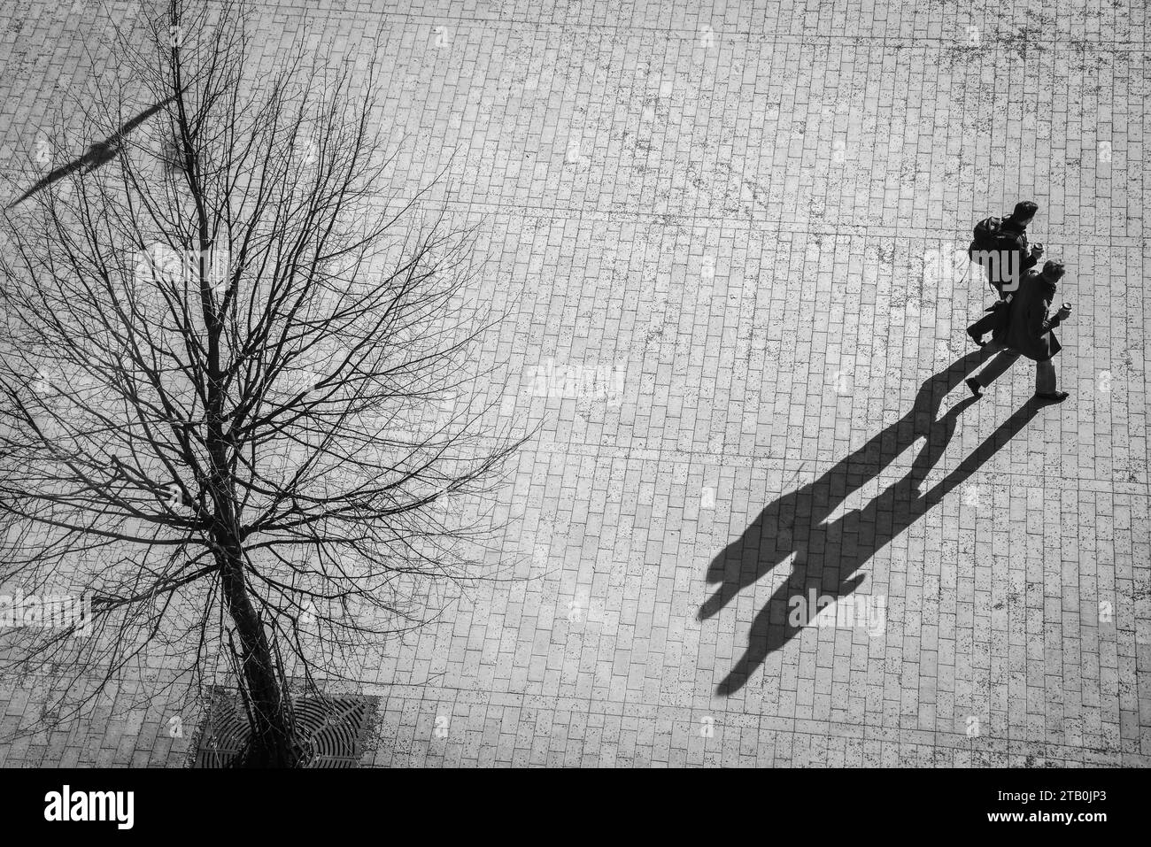 Bright sun silhouettes of people walking near the Helsinki Central Station (train station) in Helsinki, Finland. Stock Photo