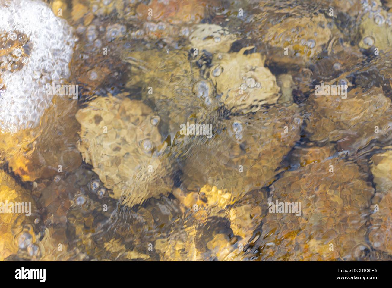 The water surface is clear, the stream below is rock Stock Photo