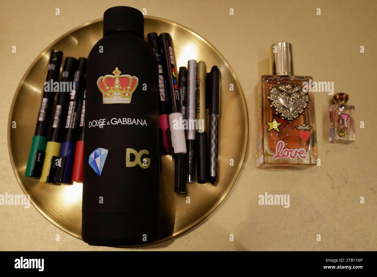 A thermos and two perfume containers from the Italian brand Dolce & Gabbana are being personalized with acrylic paint markers by Guadalupe Navarro Mabarak, a young Mexican-Lebanese illustration specialist who graduated from the Design and Visual Communication degree at the Faculty of Arts and Design of the National Autonomous University of Mexico. She is working in the facilities of the El Palacio de Hierro department store in Mexico City, on Christmas Eve, through the Design Emergency Studio agency. (Photo by Gerardo Vieyra/NurPhoto)0 Stock Photo