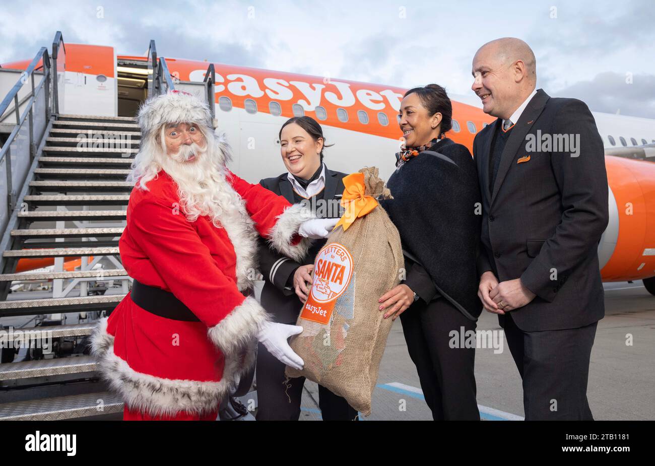 EDITORIAL USE ONLY (Left to right) Father Christmas with easyJet pilot Hannah Wells and Cabin Crew Eva Lewis and Colin Young delivering children's 'Letters to Santa' on an easyJet flight to Rovaniemi in Lapland, the home of Santa Claus, London. Issue date: Monday December 4, 2023. Stock Photo