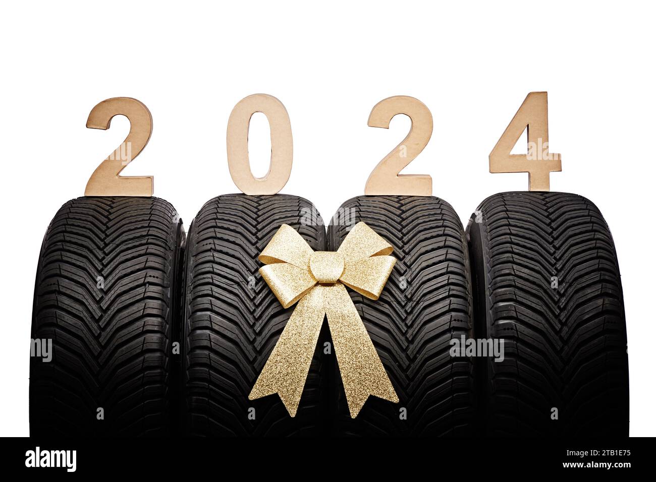 Car tires, new year 2024 tyres, winter wheels golden christmas ribbon. Stock Photo