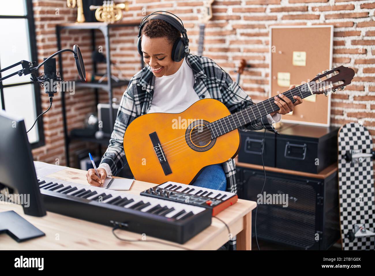 African american woman musician composing song playing classical guitar ...