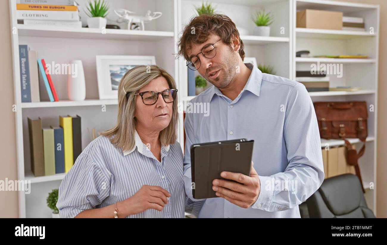 Two employees in sync, man and woman standing together in office ...