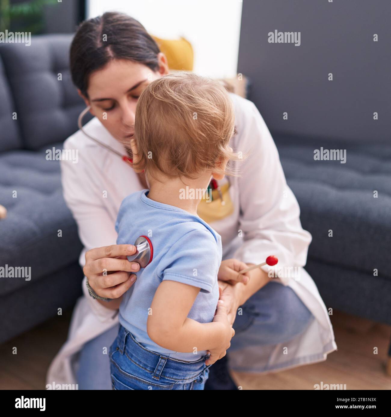 Mother and son doctor examining child at home Stock Photo - Alamy