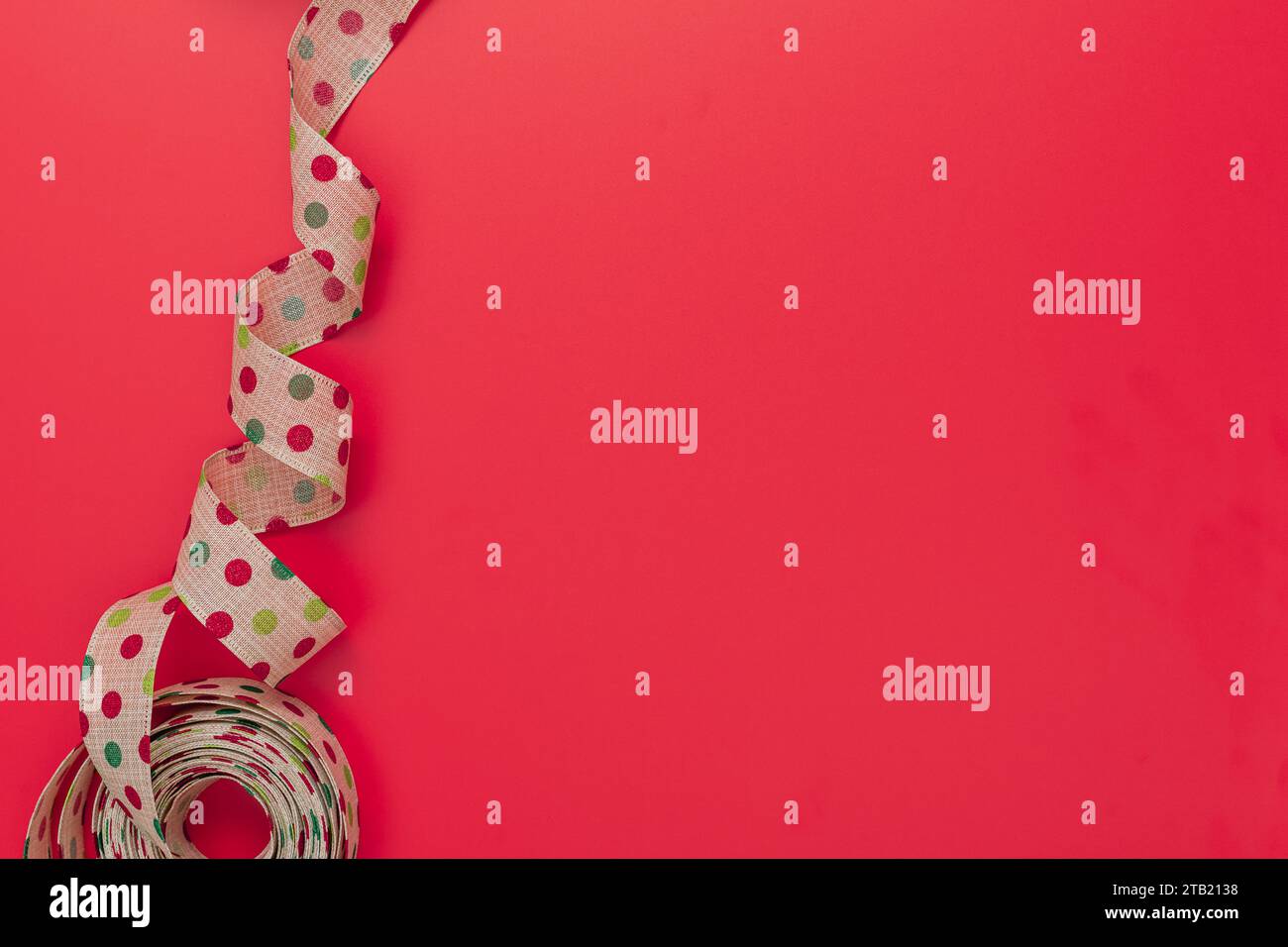 Polka Dot Ribbon on a Red Background with Copy Space Stock Photo