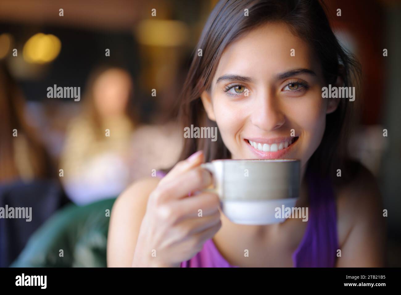 Happy restaurant customer looking at you with a coffee cup Stock Photo