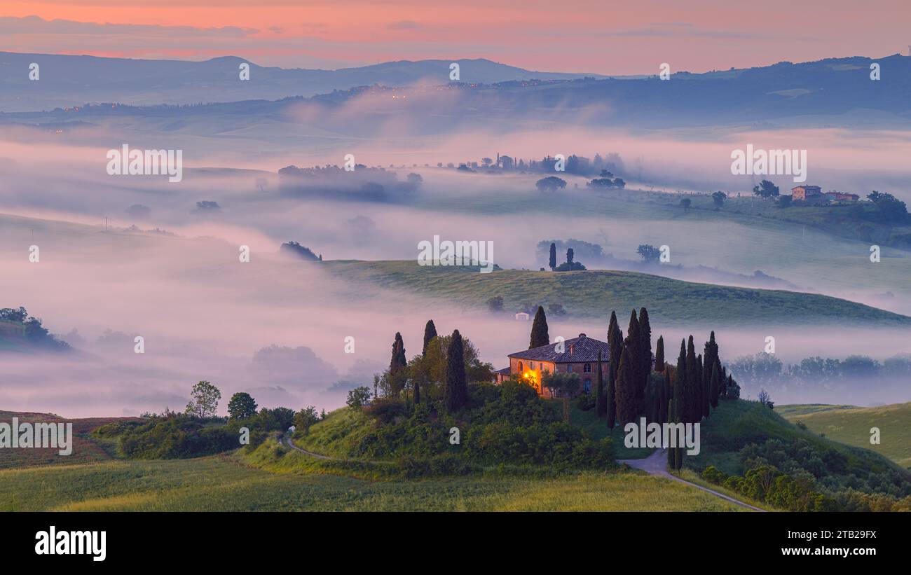 Famous Podere Belvedere in morning light with some fog over the land in the heart of Tuscany. Belvedere lies between Pienza and San Quirico d'Orcia, i Stock Photo