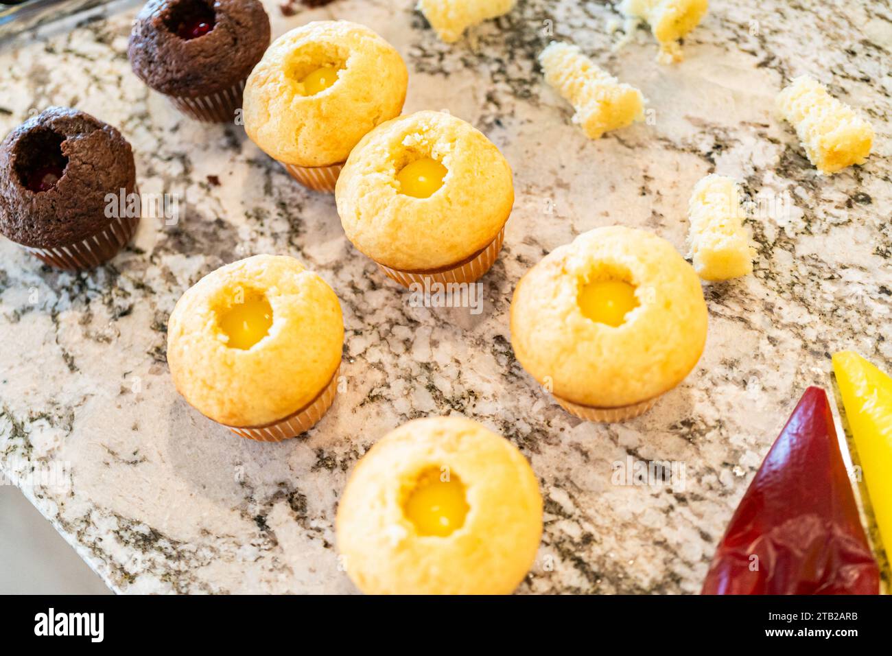 Filling Vanilla, Chocolate Cupcakes with Lemon, Raspberry Stock Photo