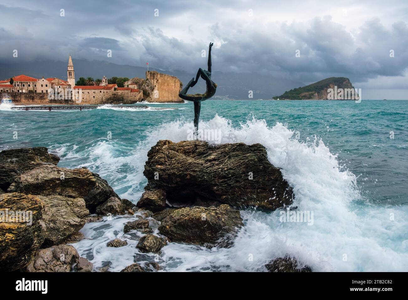 The Mogren Ballerina Statue and view to Budva Old Town on a stormy day, Montenegro Stock Photo