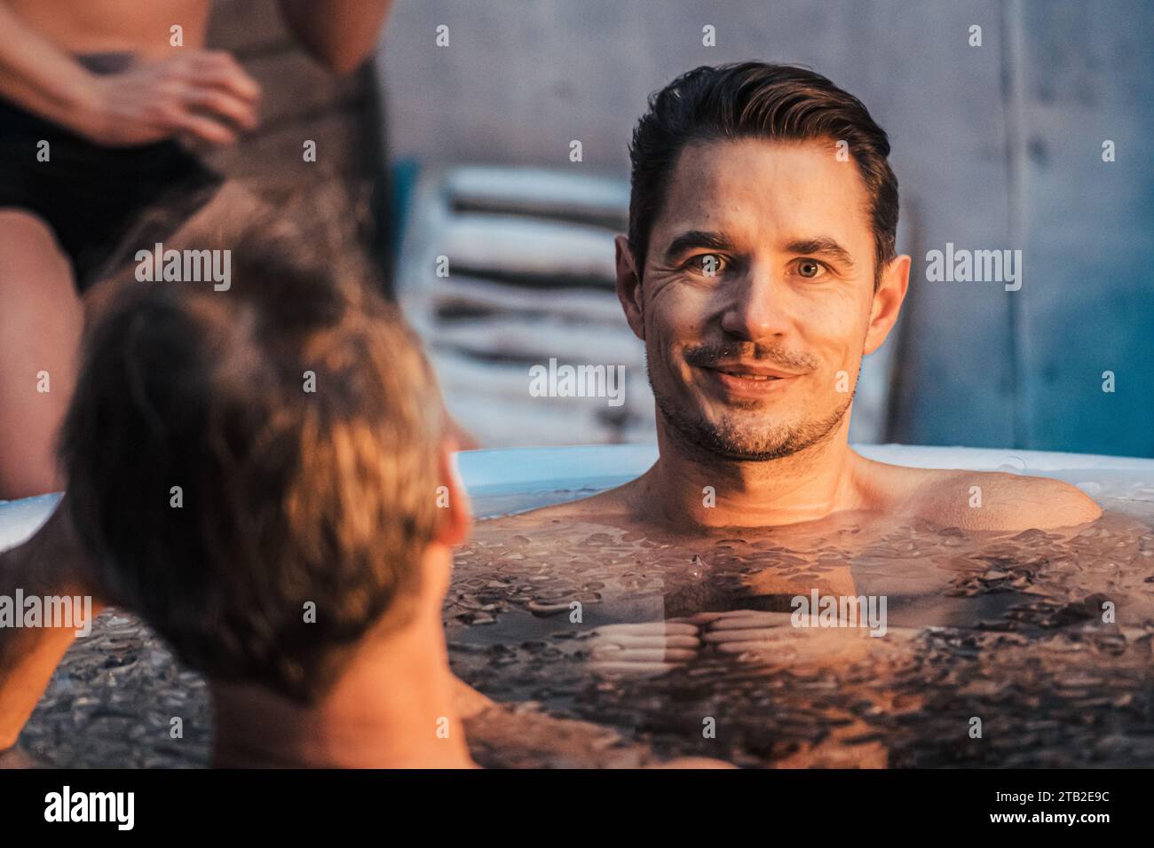 Handsome boy or man with beard ice bathing in the cold water among ice