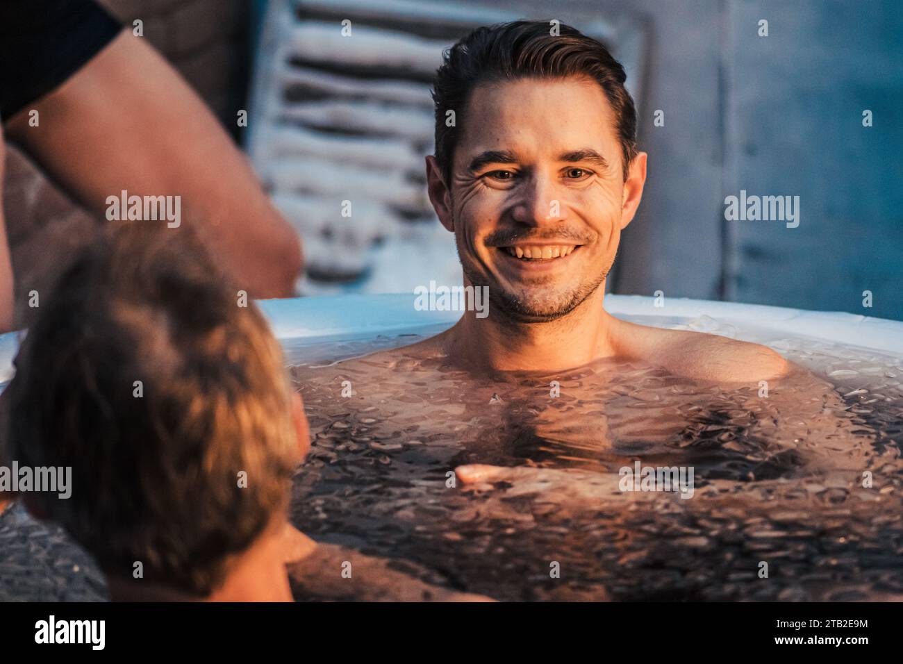Handsome boy or man with beard ice bathing in the cold water among ice