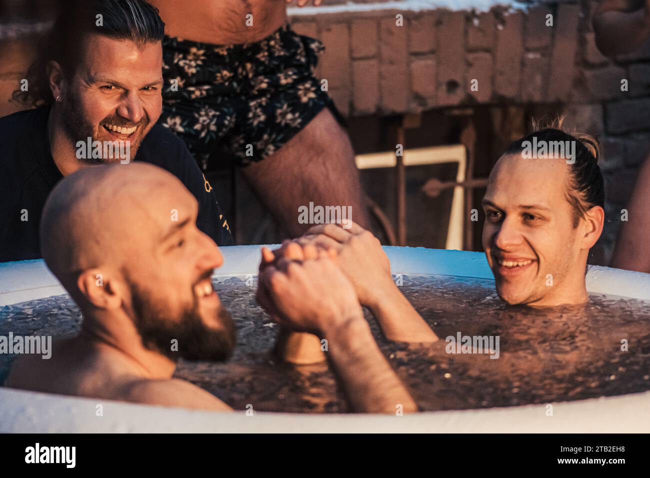 Couple of boys ice bathing in the cold water in an inflatable pool with ...