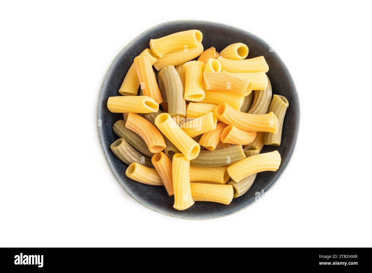 Rigatoni colored raw pasta in bowl isolated on white background. Top ...