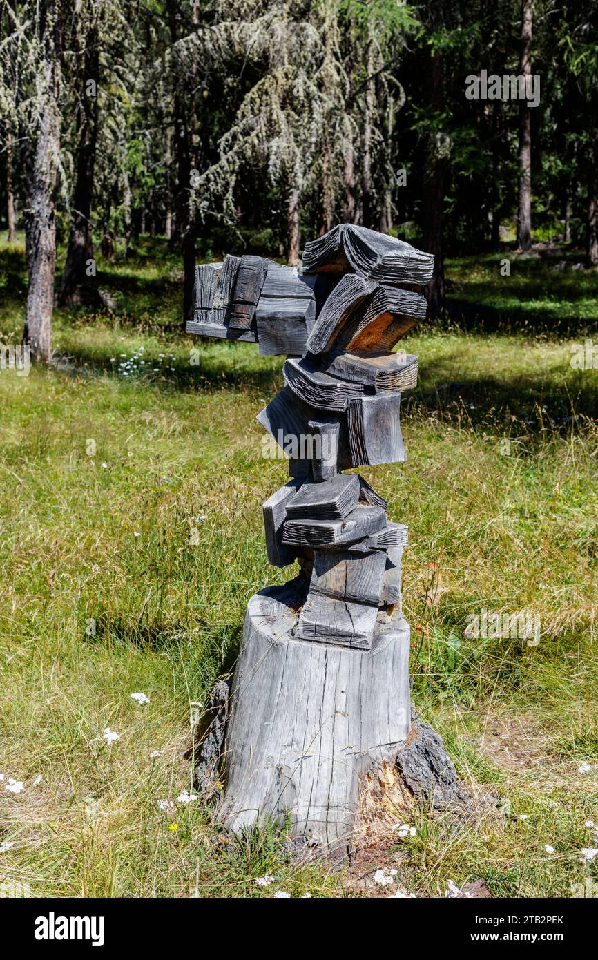 Dead larch trunk carved in the shape of overlapping books (Ayas Valley, Aosta Valley, Italy). Stock Photo