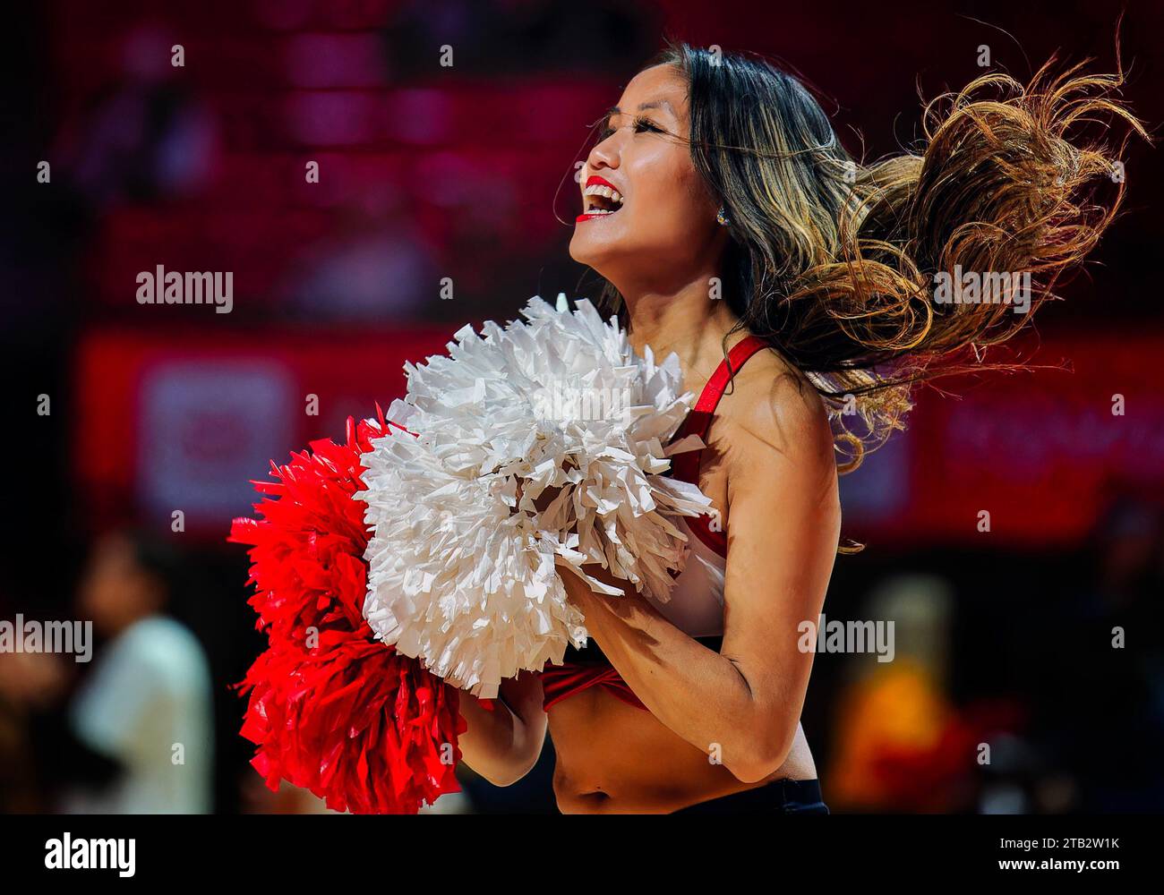A cheerleader performs at a college basketball game Stock Photo