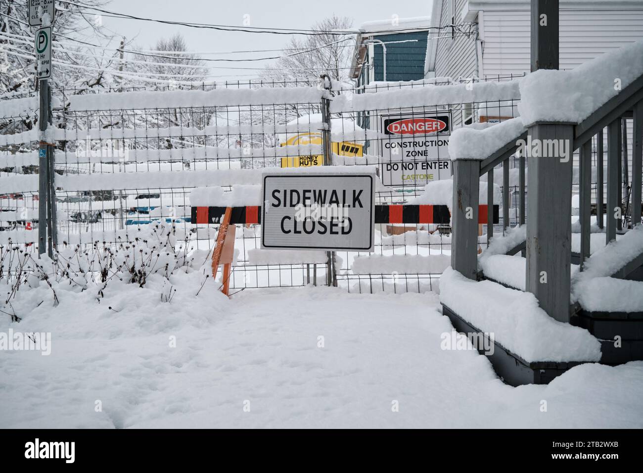 Halifax, Nova Scotia, Canada. December 4th, 2023. Sidewalk closed sign due to construction, with sidewalk covered in snow following storm making hard for pedestrians Stock Photo