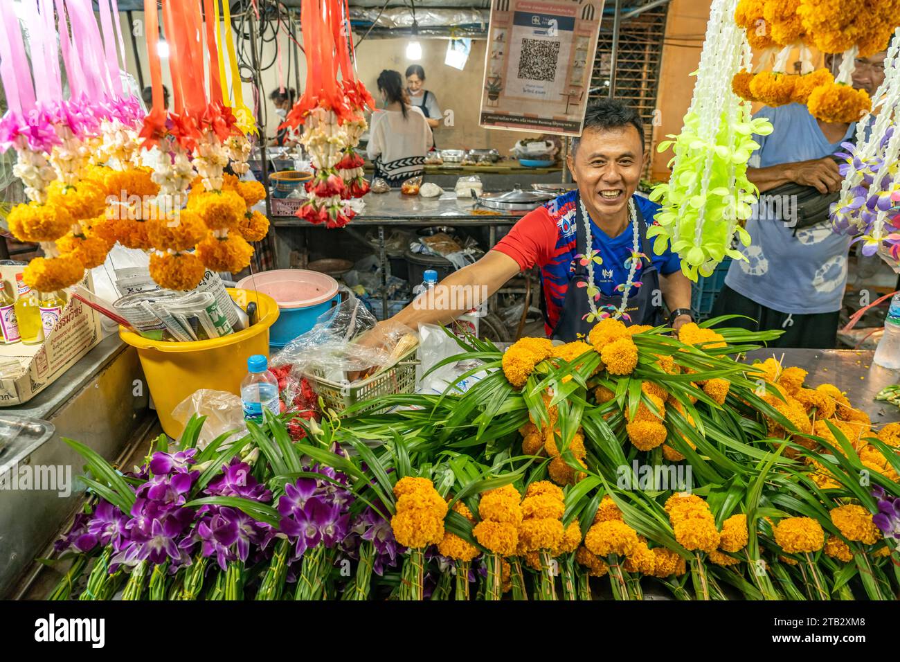 Verkäufer an seinem Stand mit Blumen auf dem Nachtmarkt in Trat
